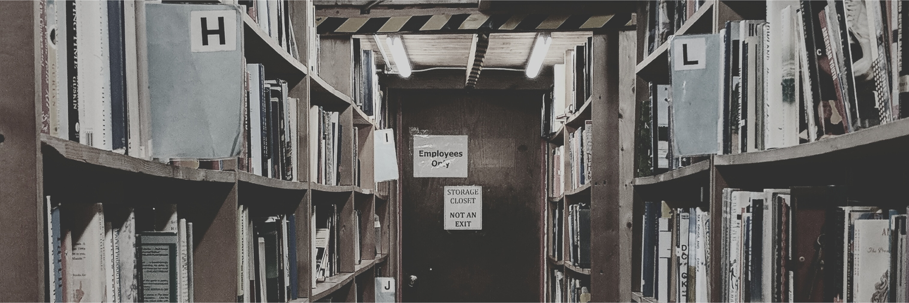 Bookshelves in a bookstore with a door that says Employees Only