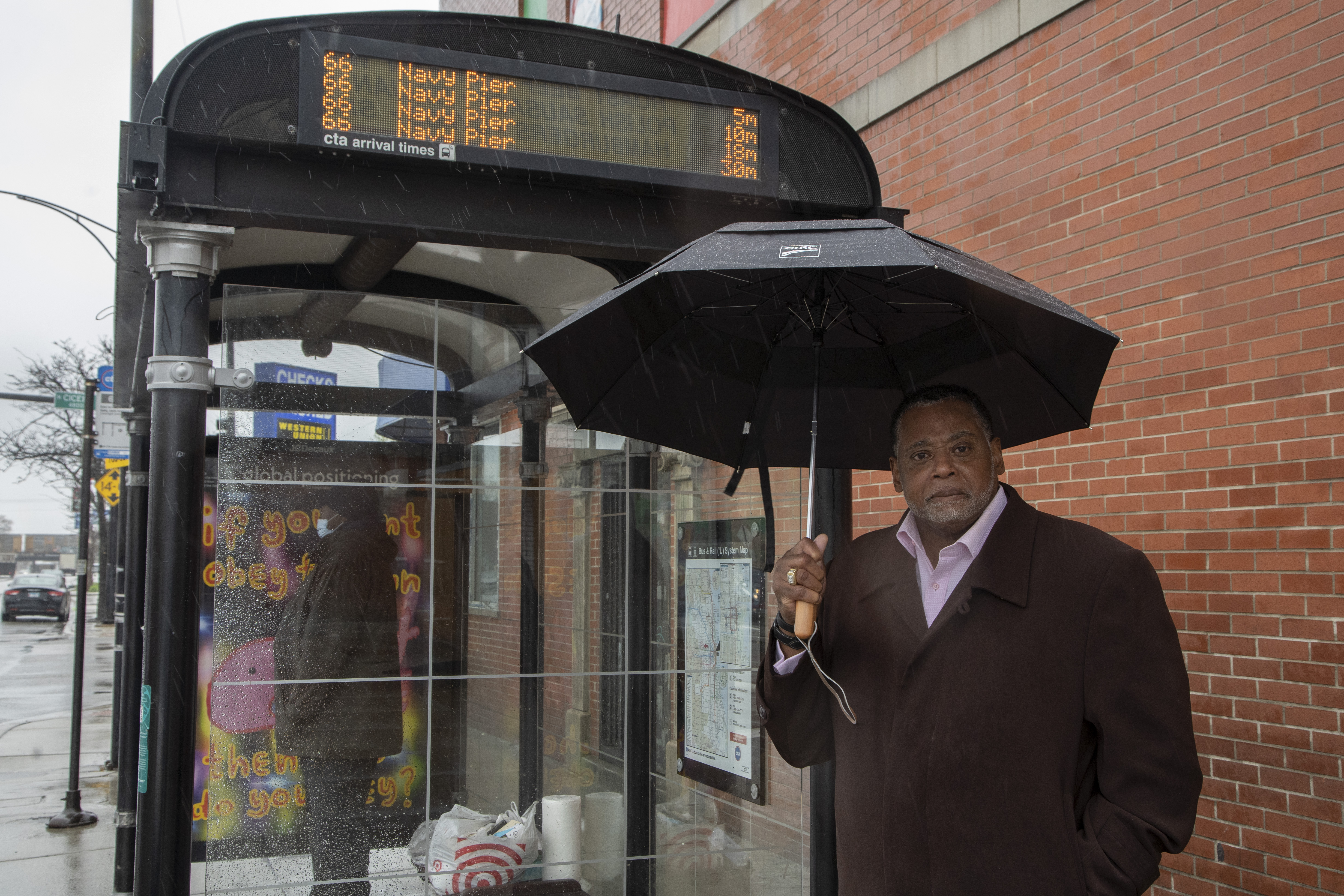 The Rev. Joseph Kyles, who has been pastor at The Promise Church of Chicago for 17 years, stands at the bus stop at Chicago and Cicero in Austin.